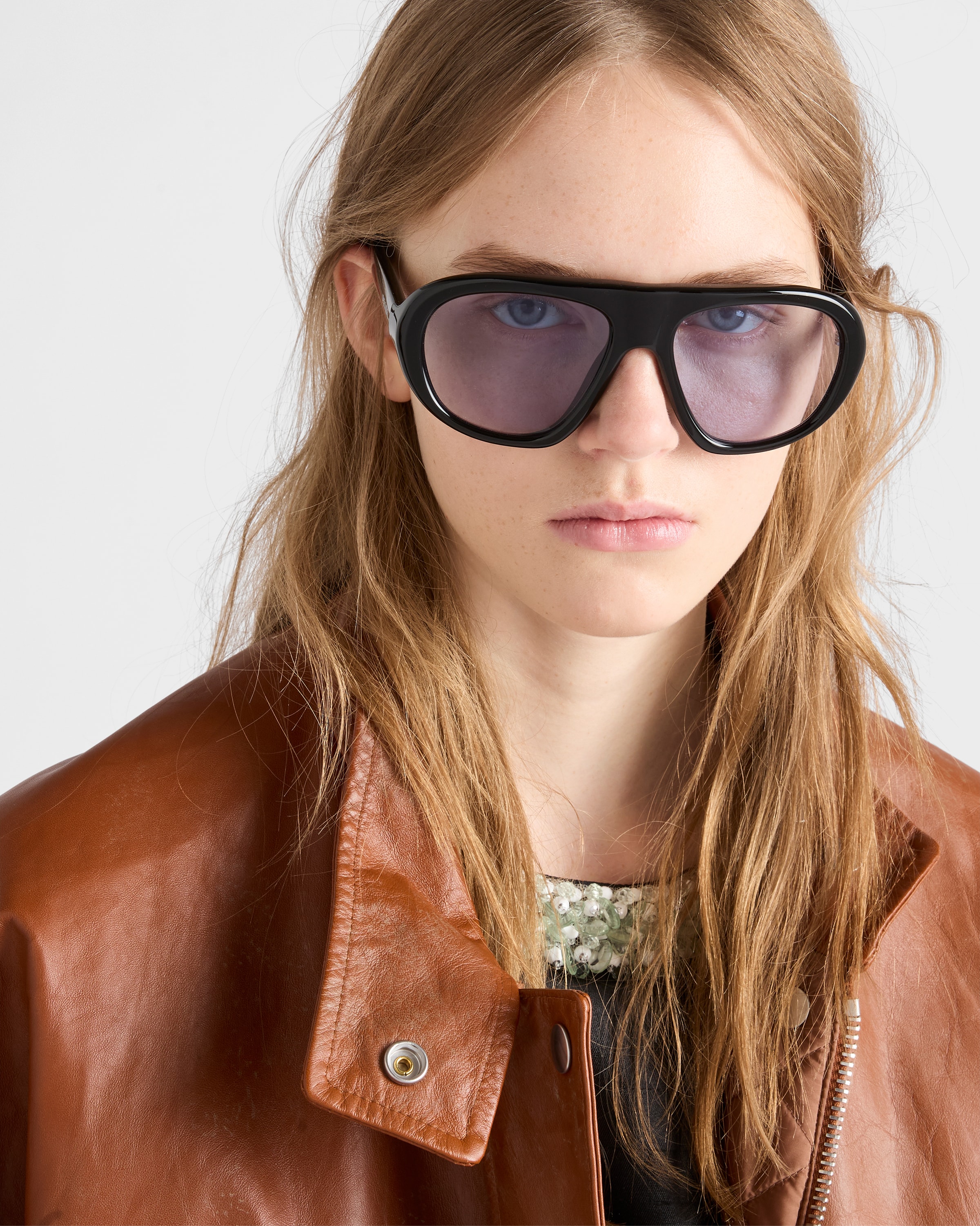 Official Prada eyewear portrait with black frames and lilac lenses