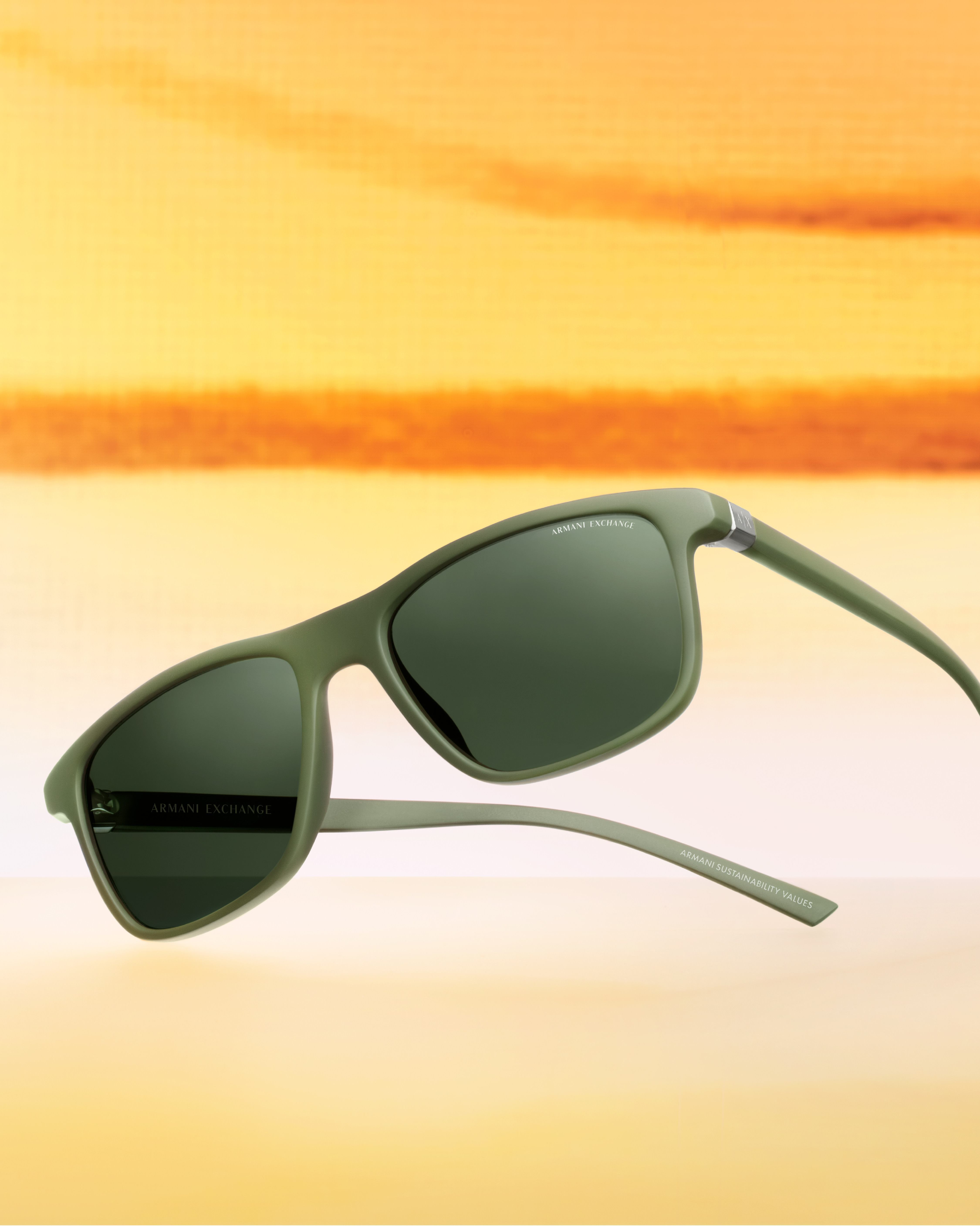 Armani Exchange sunglasses against a warm yellow campaign background
